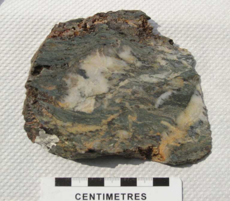Colour image of gray rock with gold, white and orange streaks