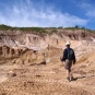 Photographie couleur d’un homme traversant une étendue de rochers blancs dans la carrière