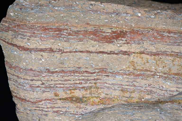 Colour image of gray rock with horizontal red striping